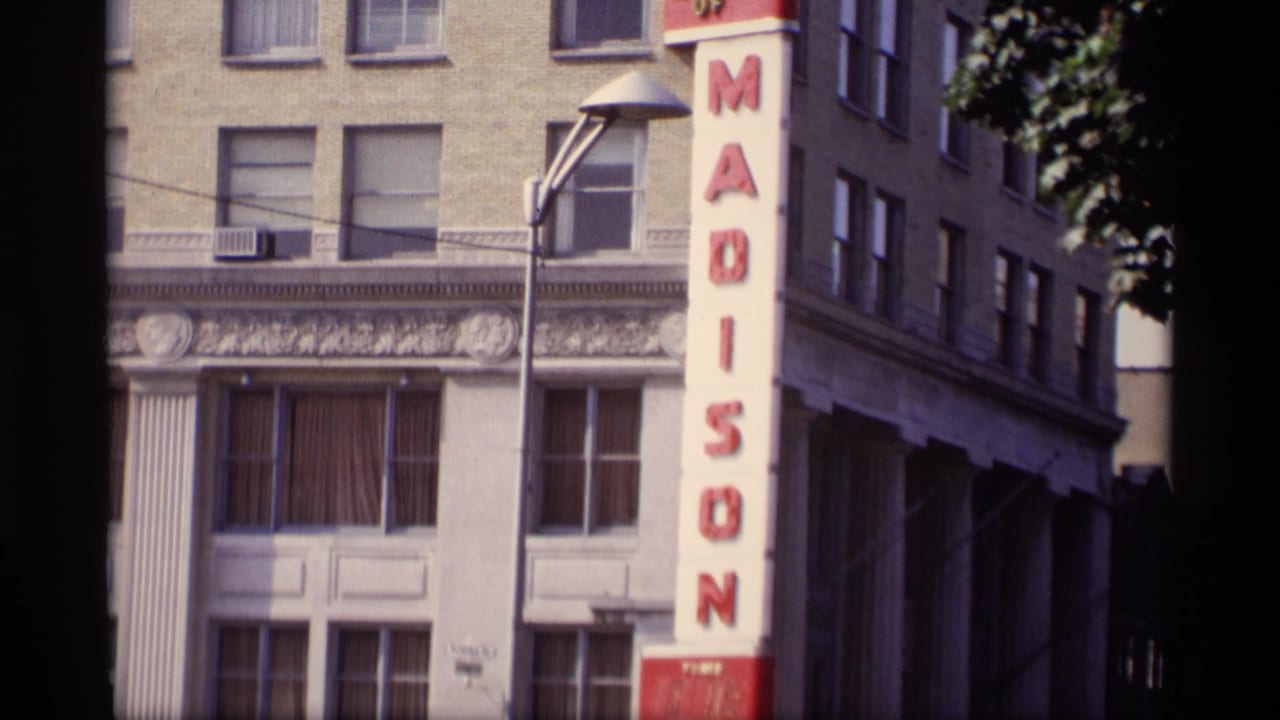 Madison building facade with a red vertical sign and streetlight in front.