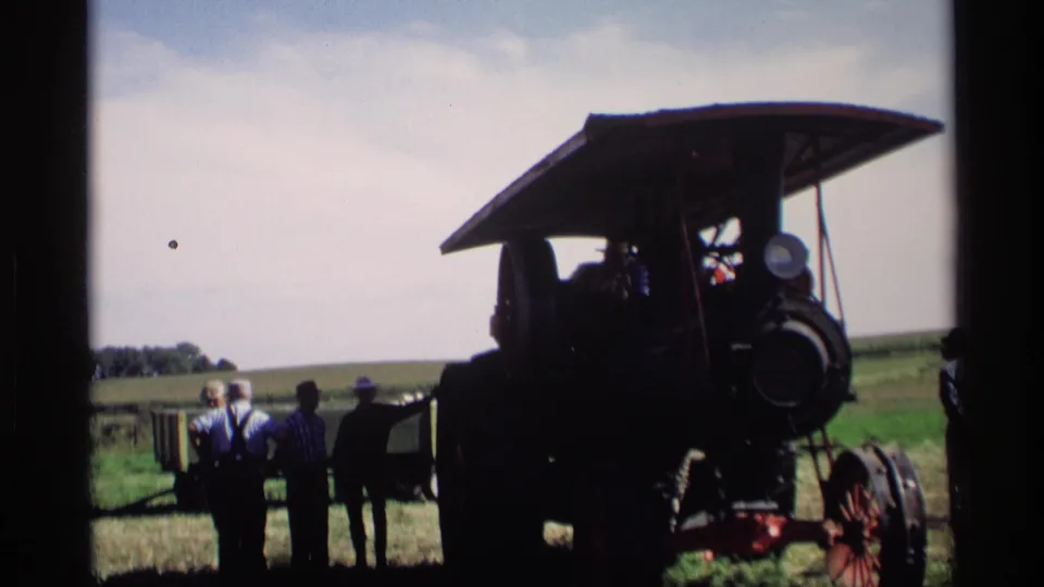 1969 Mabel, Minnesota home-movie frame of a steam tractor and observers in a grassy rural setting.