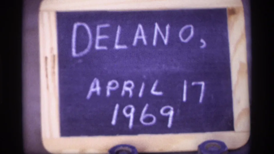 Close 8mm frame of a handwritten board reading Delano, April 17, 1969, used as a home-movie date and place marker.