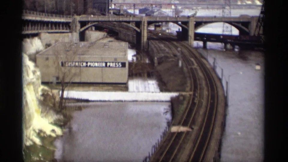 1969 Saint Paul view of curved rail tracks, a Naval Reserve building and floodwater around bridges and riverfront structures.
