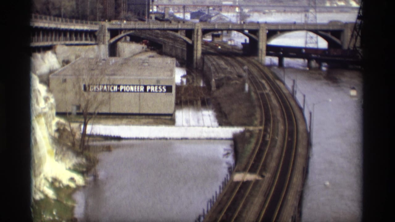 1969 Saint Paul riverfront view with rail tracks, bridge spans, snow, and a building labeled Dispatch-Pioneer Press.