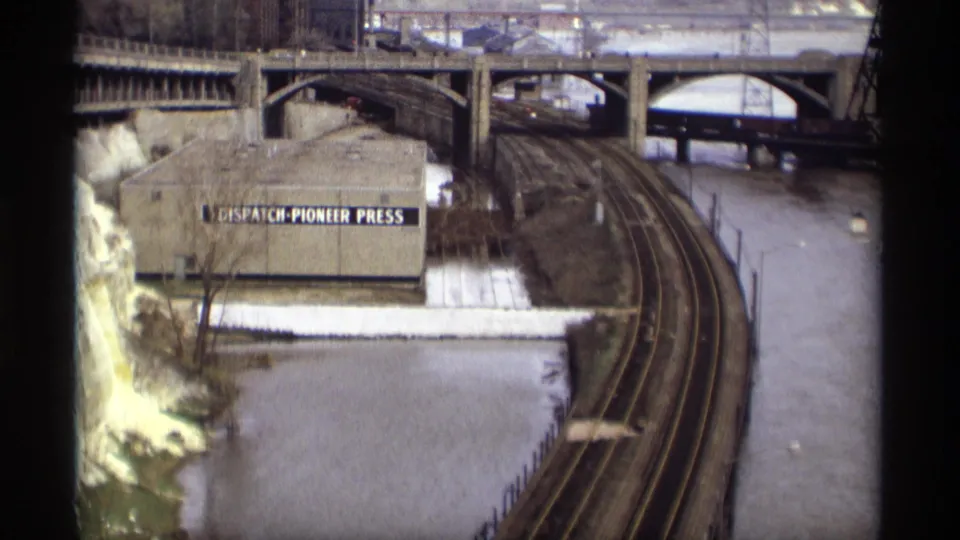 1969 Saint Paul riverfront view with rail tracks, bridge spans, snow, and a building labeled Dispatch-Pioneer Press.