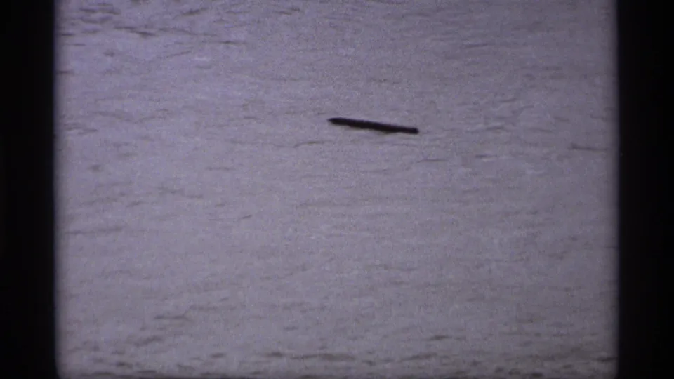 Saint Paul, Minnesota flood footage from 1969 showing a dark elongated object drifting across turbulent water.