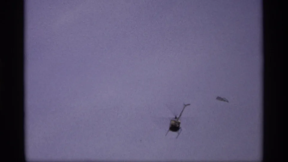 A helicopter appears over the Saint Paul flood scene, with murky water and road signage low in the frame.