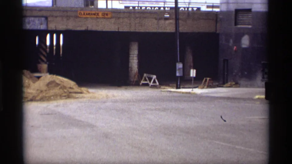 1969 Saint Paul roadway view toward a concrete underpass, with sand piles, barricades, street signs, and dark tunnel entrances visible.