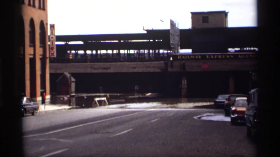 Saint Paul street view under an elevated railway bridge, with late-1960s cars and a Railway Express Agency sign visible.