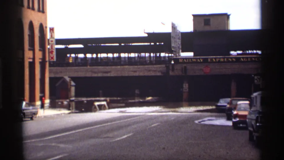 1969 Saint Paul streetscape showing the elevated railway bridge, parked cars, brick buildings, and Railway Express Agency signage.