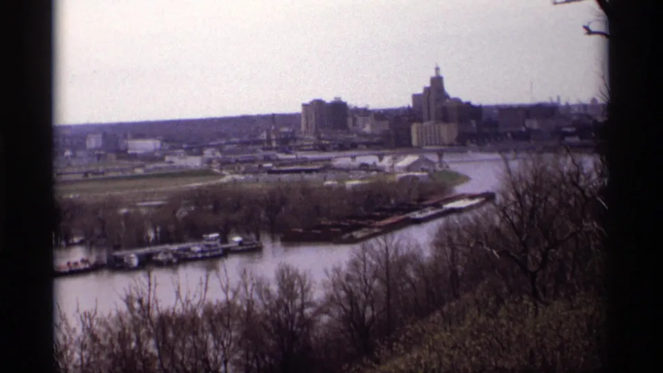 Saint Paul riverfront seen from an elevated park overlook, with skyline buildings beyond the Mississippi River.