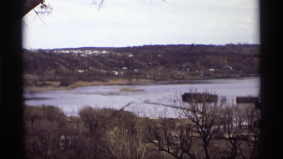 Saint Paul, Minnesota riverfront in 1969, showing high water, leafless trees, docks, and scattered houses across the hillside.