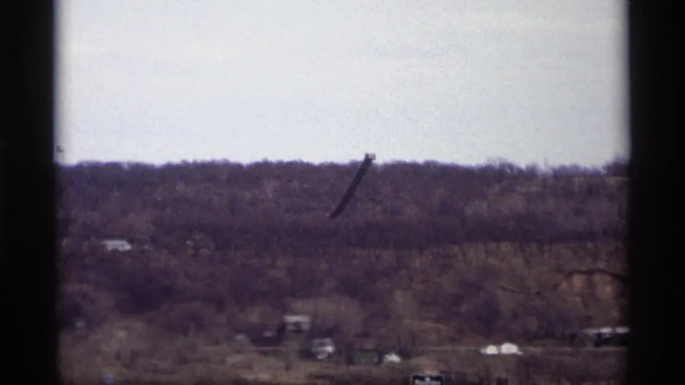Distant Saint Paul ridge in 1969 footage, with a dark industrial-looking structure above the treeline.
