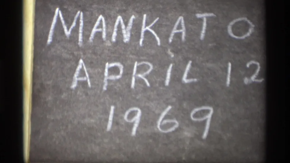 Soft 8mm close-up of a chalkboard sign labeled Mankato, April 12, 1969.