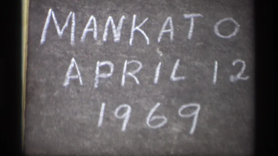 Tighter, soft-focus 8mm view of the handwritten Mankato April 12 1969 chalkboard.
