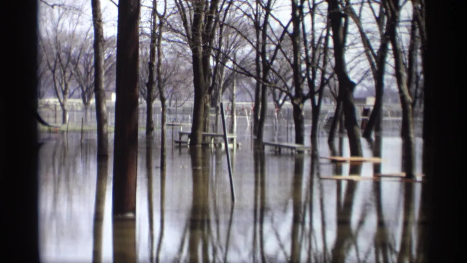 Savage, Minnesota flood scene showing picnic tables and leafless trees partly surrounded by still water in 1969 8mm footage.