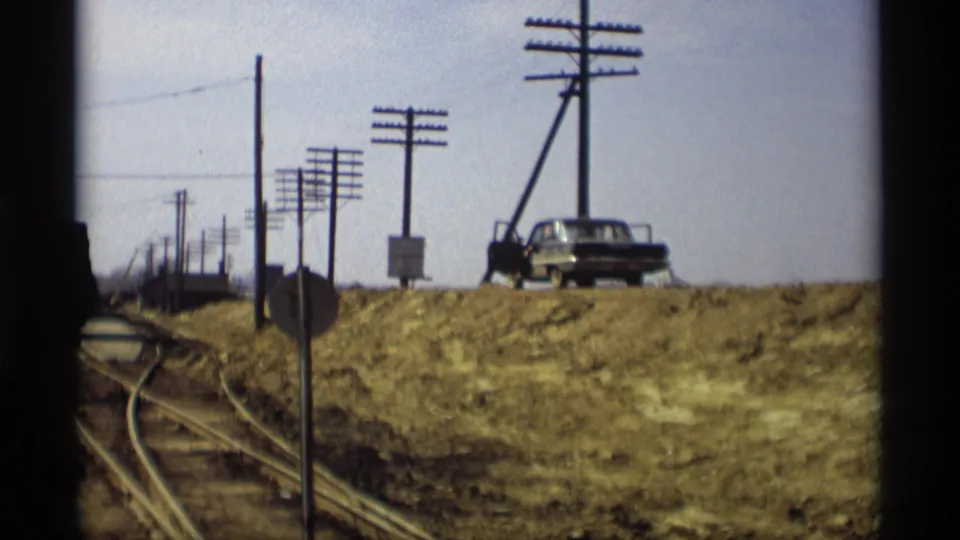 Savage, Minnesota flood footage from 1969 showing a parked car near utility poles, with water and roadside infrastructure visible below.