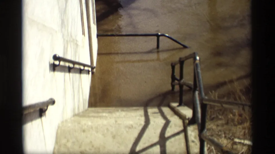 1969 Savage, Minnesota 8mm frame showing concrete steps and black metal railings with floodwater covering the lower landing area.