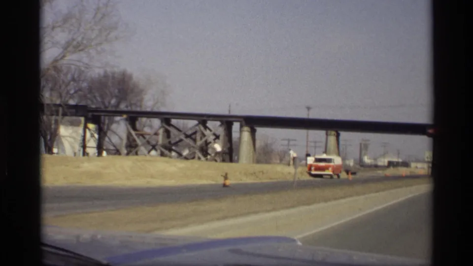 1969 Savage, Minnesota highway view with a red-and-white van, large trestle bridge, bare trees, and open roadside.