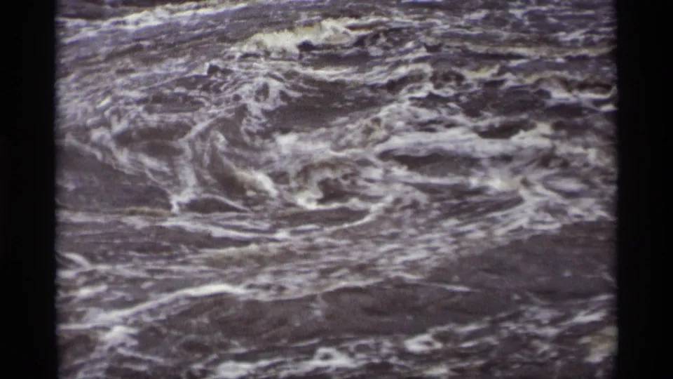 1969 8mm frame from Savage, Minnesota showing swirling foamy runoff water with visible film-frame edges.
