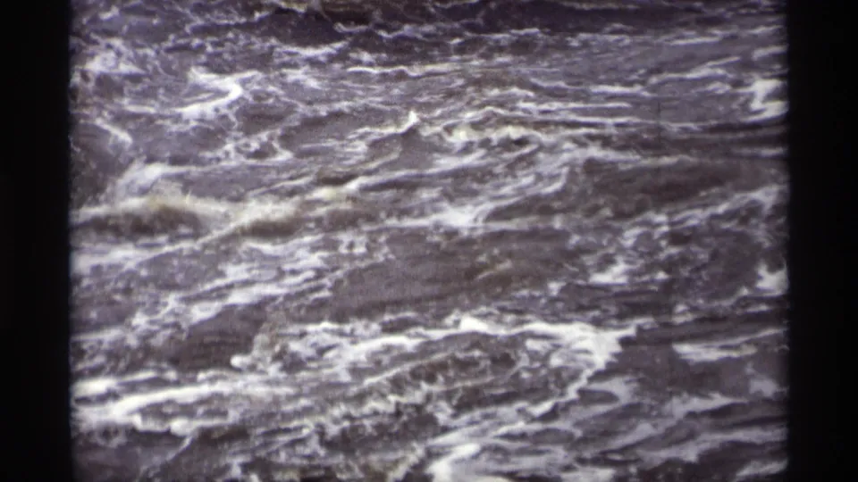 Vintage 8mm frame showing foamy, agitated runoff water, consistent with the Savage, Minnesota dam footage metadata.