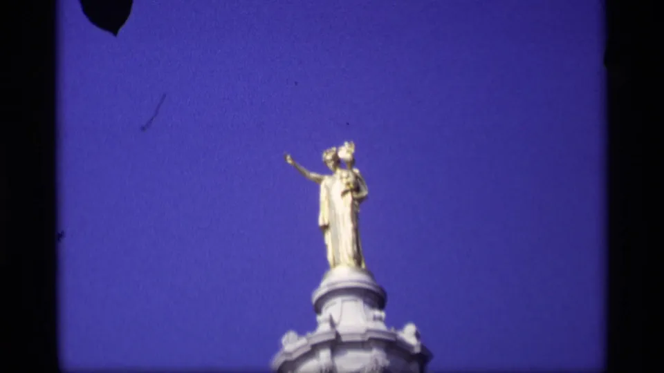 1969 Wisconsin State Capitol statue detail, centered against blue sky with the dome top visible below.