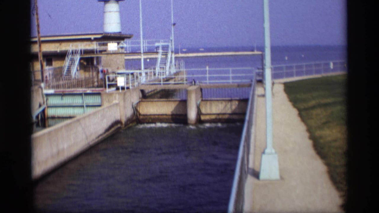 Lock-side building and concrete water channel viewed from an elevated walkway.