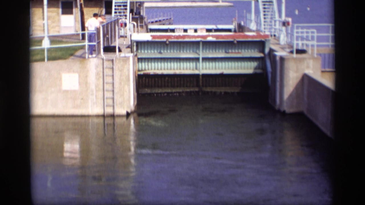 1969 Wisconsin home-movie frame with the drawbridge gate raised slightly, revealing machinery and water below.