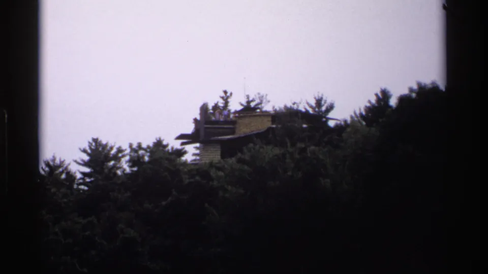 A soft 8mm view of the Castle Rock area, with a hilltop structure partially visible beyond trees.