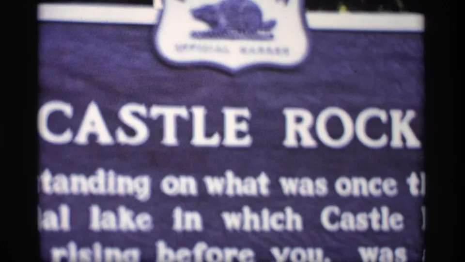 Cropped close-up of the Castle Rock sign, showing large white lettering and a small emblem at the top.