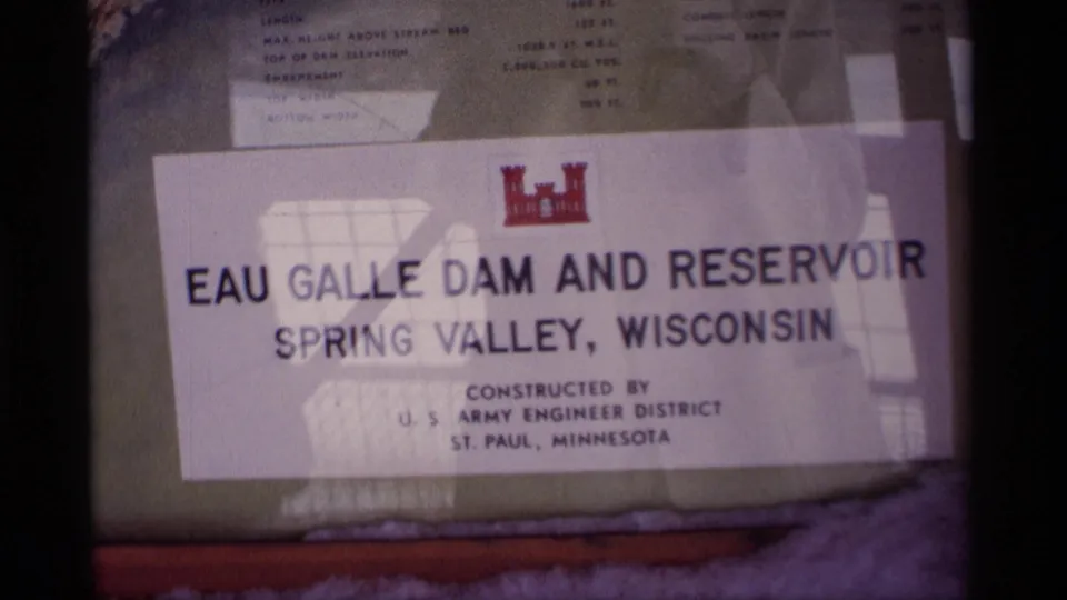 Close 8mm frame of the Eau Galle Dam and Reservoir sign for Spring Valley, Wisconsin, with visible official insignia.