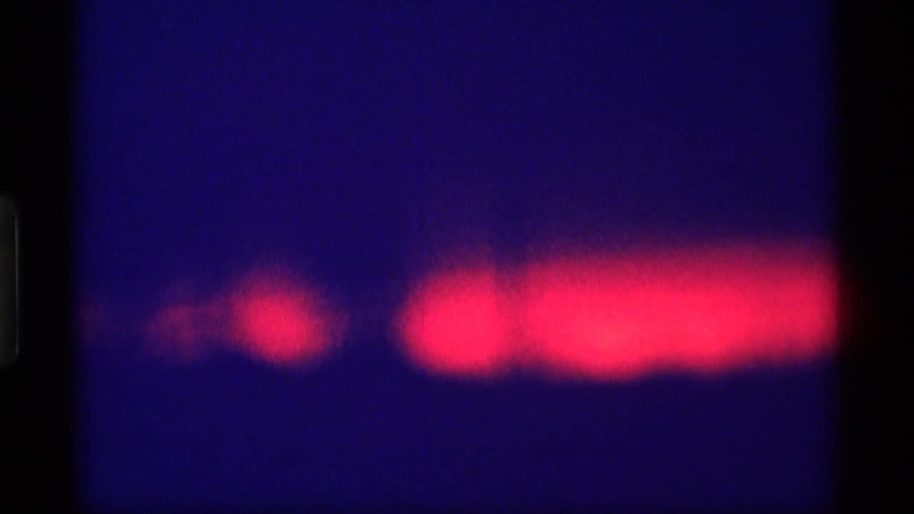 Red horizontal glow against a deep blue night sky with dark film edges.