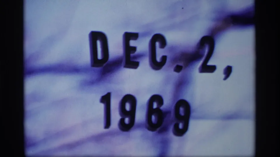 Close 8mm frame of the Dec. 2, 1969 date card, showing bold black text, grain, and color shift from the scanned film.