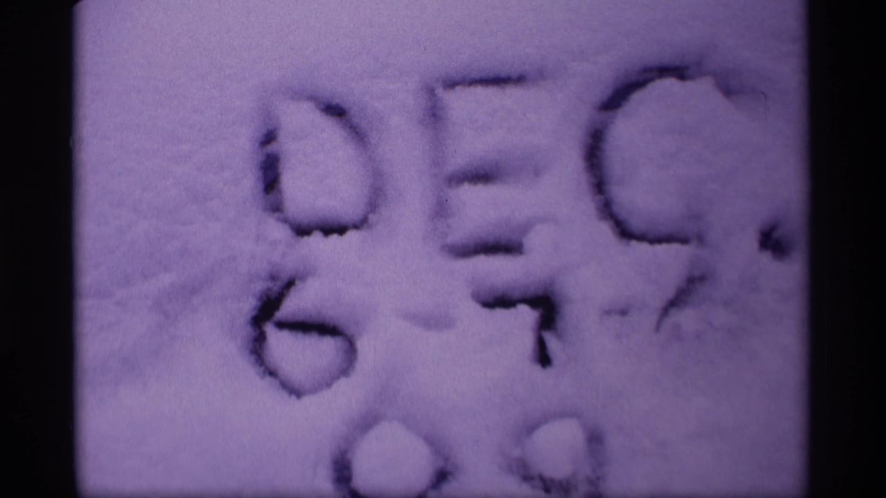 Close view of letters or shapes formed in snow on a tinted film frame.