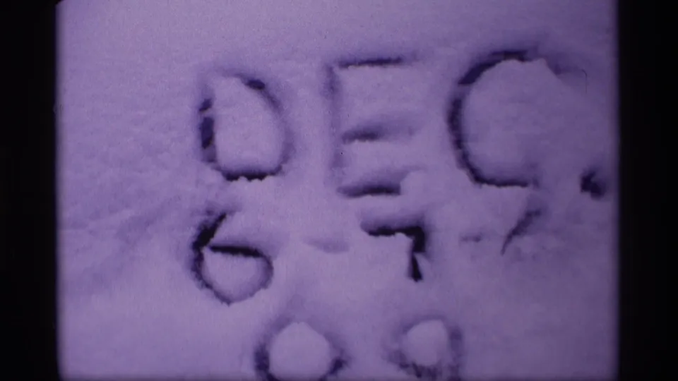 Close 8mm view of a snow inscription in Wisconsin, with grain, soft focus, and purple color shift.