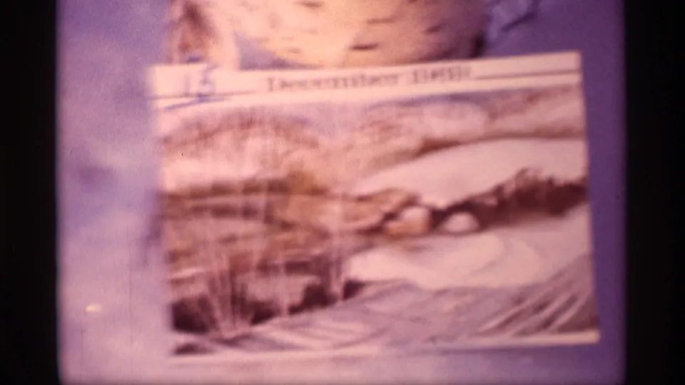 Soft 8mm close-up of a snowy landscape postcard or card detail labeled December 1969.