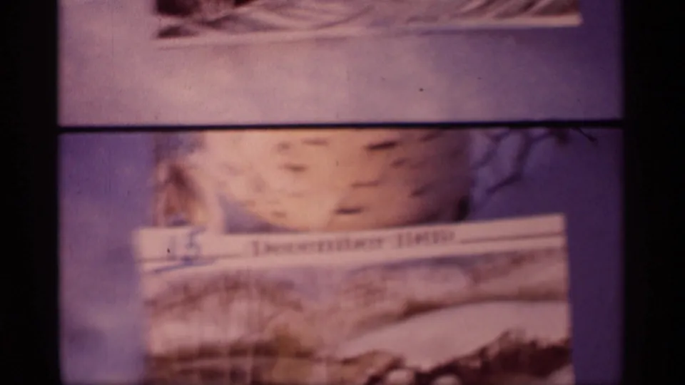 Close-up of the dated winter postcard in the 1969 home-movie clip, with snow artwork and visible film grain.
