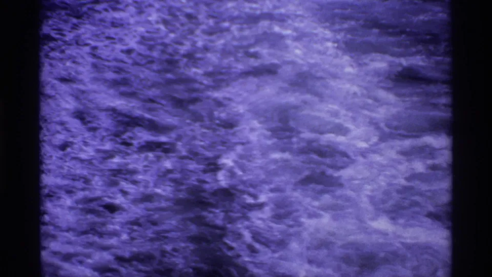 End frame from the 1974 Canada ferry clip showing foaming wake and rippled water in faded 8mm color.