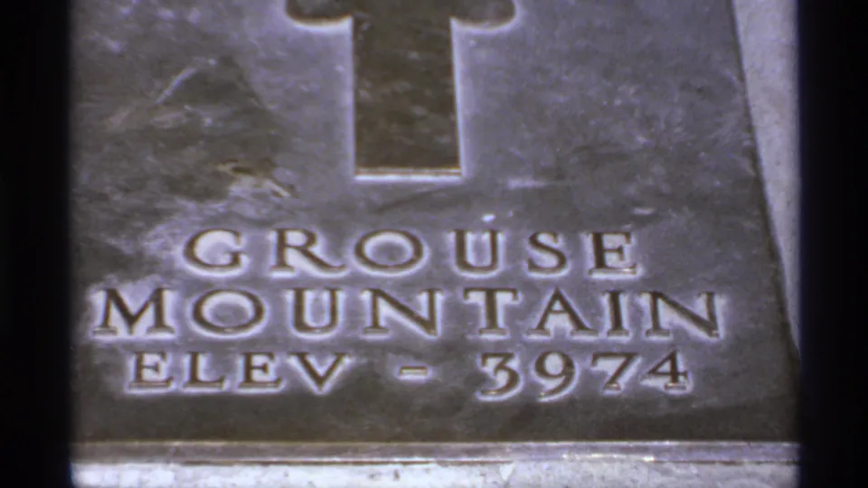 1974 Canada 8mm frame showing a weathered Grouse Mountain elevation marker inscribed ELEV - 3974.