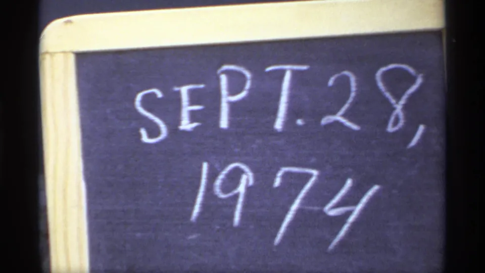 A cropped 8mm view of the handwritten SEPT. 28, 1974 chalkboard date slate, with soft focus and dark frame edge.