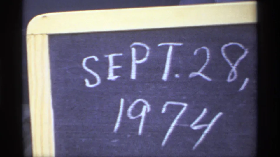 Another close frame of the home-movie chalkboard slate showing SEPT. 28, 1974, with soft 8mm grain and visible border.