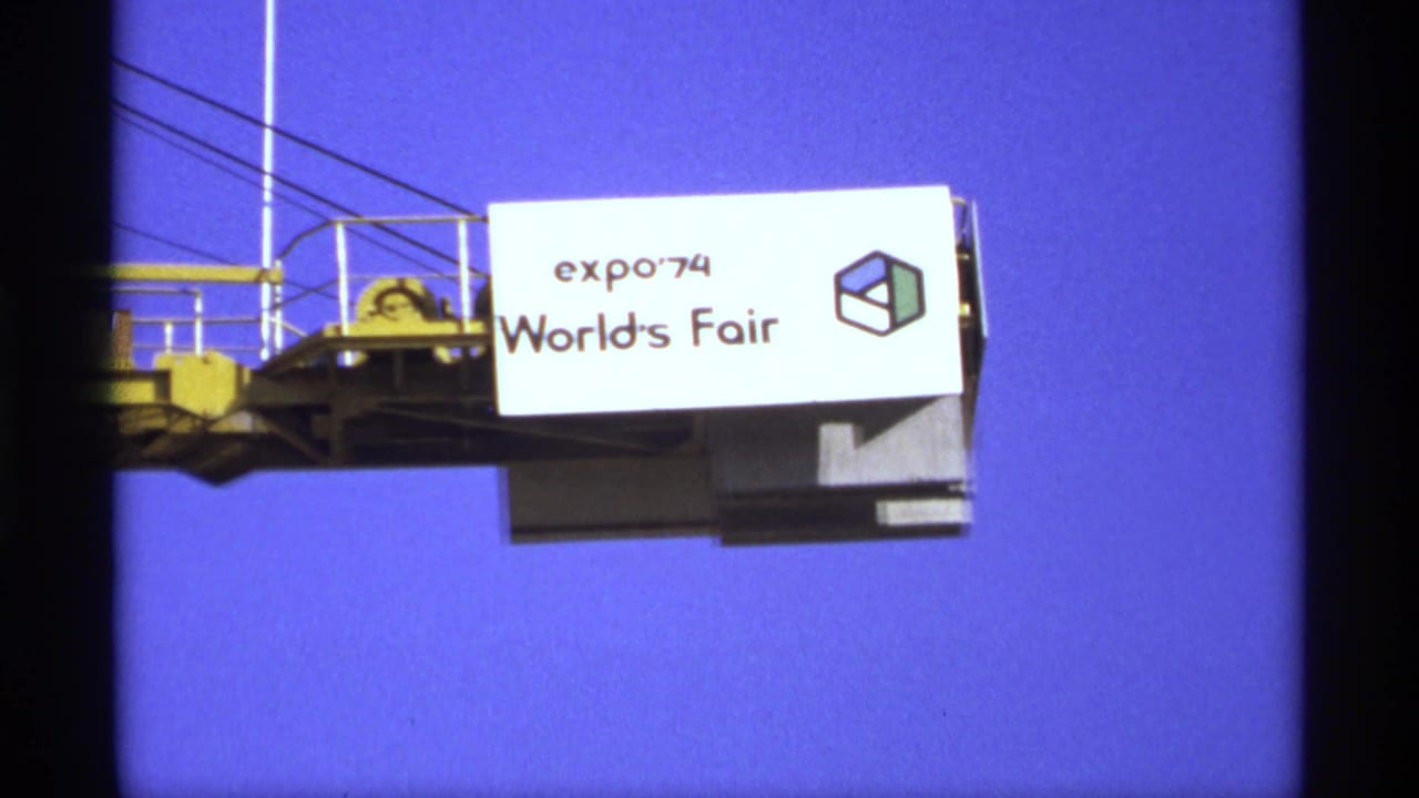 Expo '74 World's Fair sign mounted on a structure against a deep blue sky.