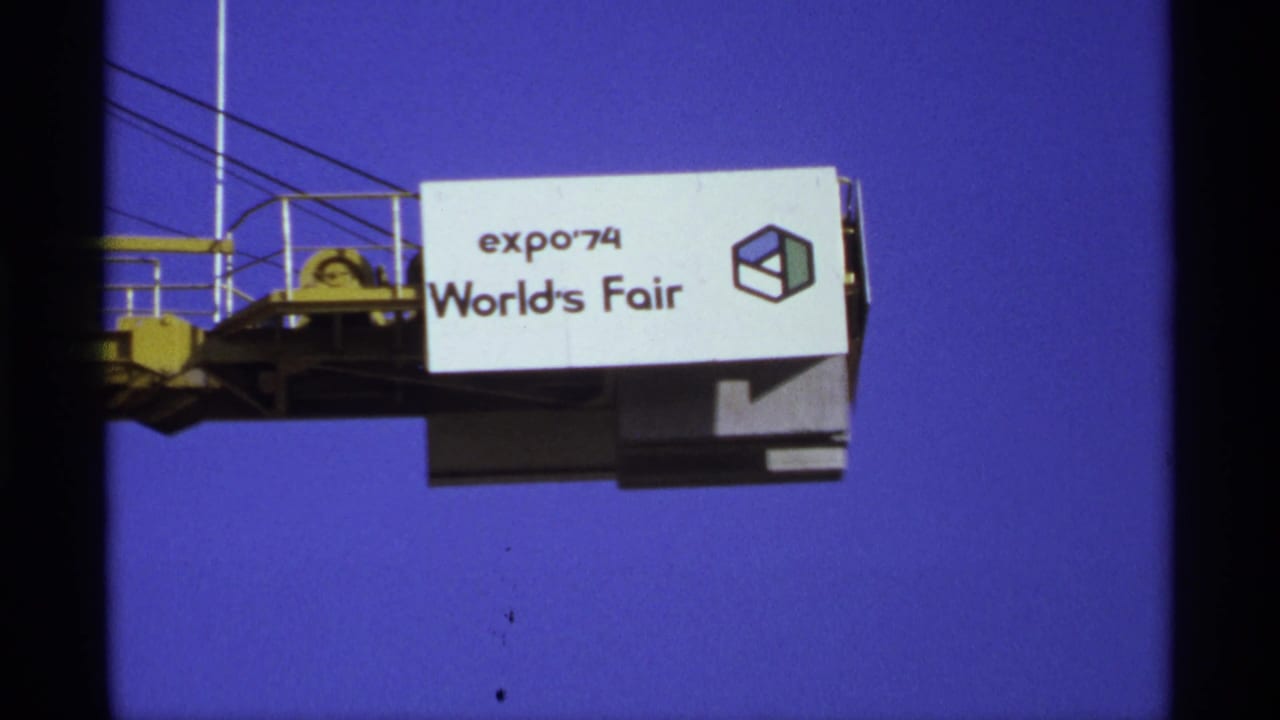 Expo '74 World's Fair sign with cube graphic on a raised structure.