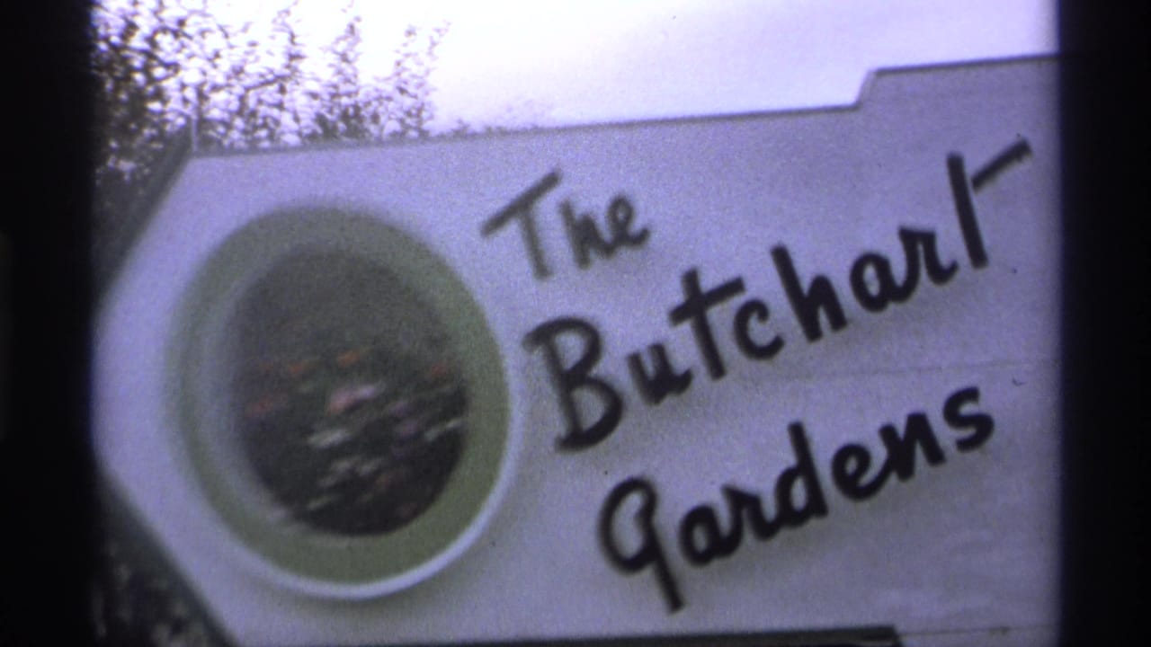 The Butchart Gardens sign seen closer, with black lettering and circular floral emblem.