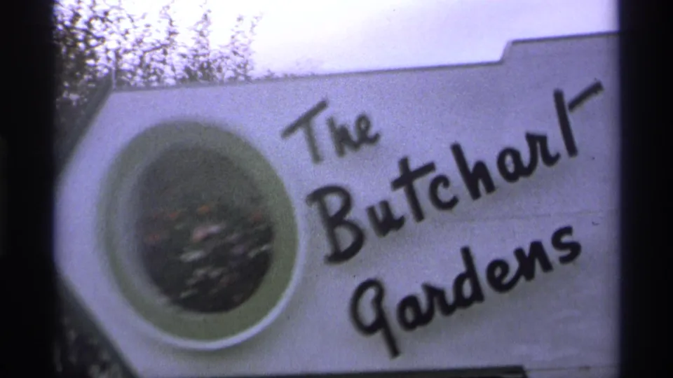 Soft 8mm view of The Butchart Gardens sign, showing the black cursive name and circular flower graphic.