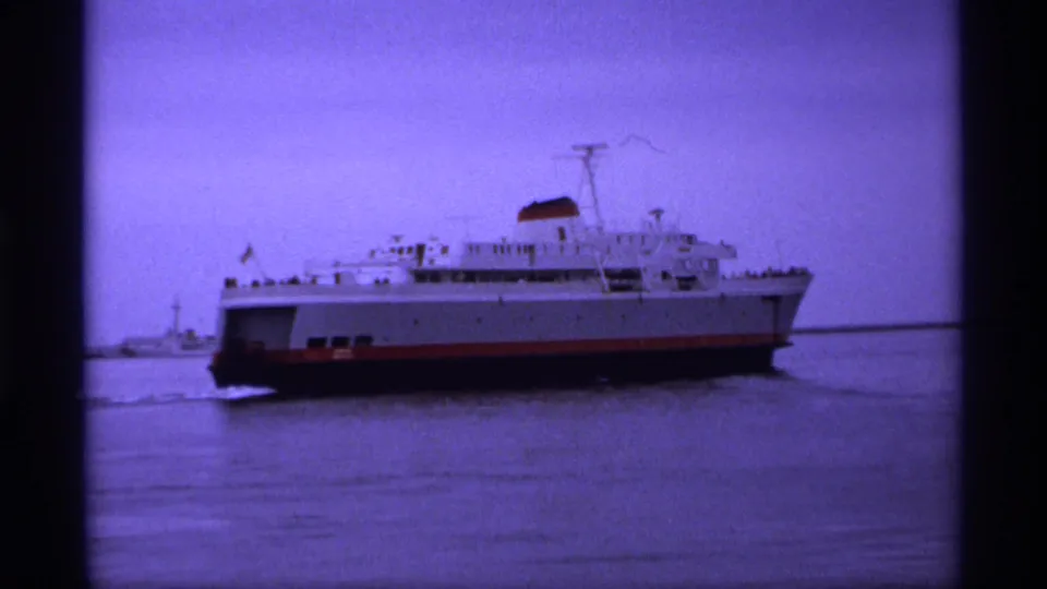 1974 Vancouver-area ferry scene showing a white passenger vessel, red hull stripe, calm water, and a small nearby boat.