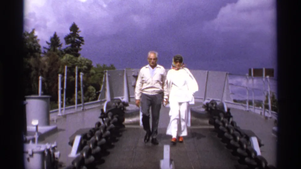 A 1974 Vancouver home-movie still shows the couple nearer to camera on a paved bridge path with heavy chains at both sides.