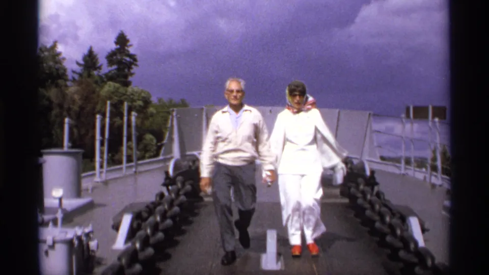 Near the end of the 1974 Vancouver clip, the couple approaches close to camera on the bridge walkway under a purple-tinged sky.