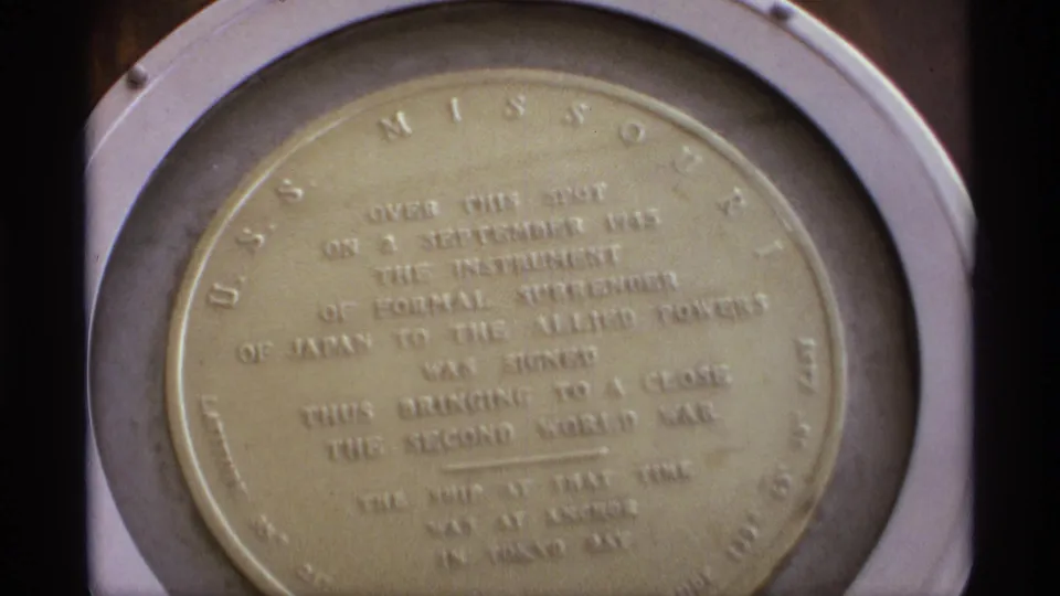 Close-up of the USS Missouri plaque marking the site of Japan's Instrument of Surrender, filmed from a visitor viewpoint.