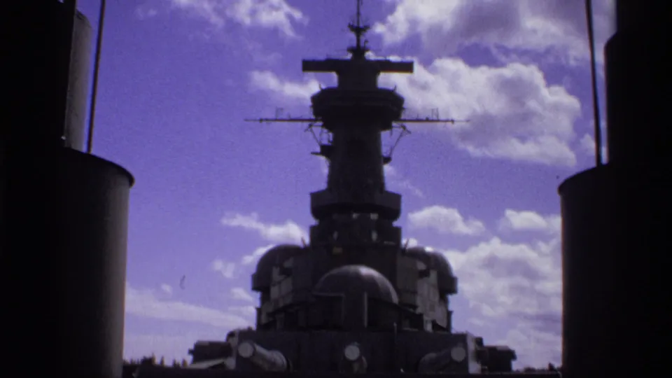 1974 Vancouver frame of the USS Missouri superstructure with deck details visible below a clouded sky, shot from a low angle.