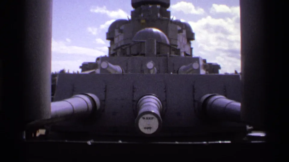 1974 Vancouver view of USS Missouri gun turrets and superstructure, with dark vertical ship elements framing the deck-level composition.