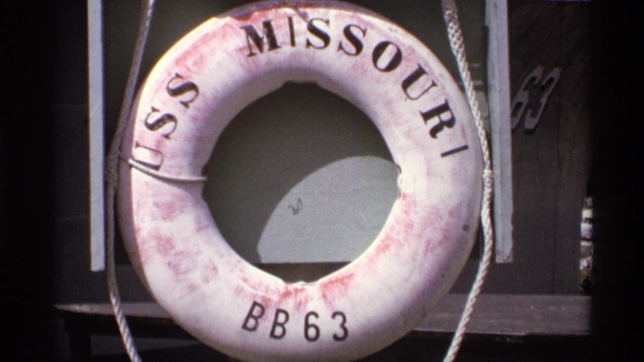 White life preserver marked USS Missouri BB63 hanging on a dark ship structure.
