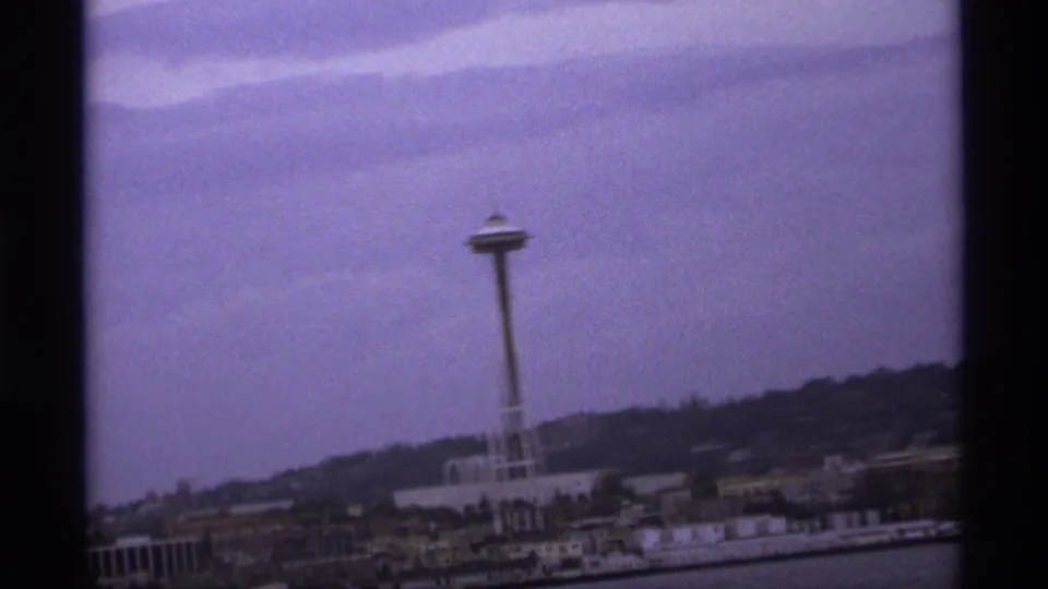 Distant view of the Space Needle over waterfront structures and a hillside, framed by visible 8mm contact-sheet borders.